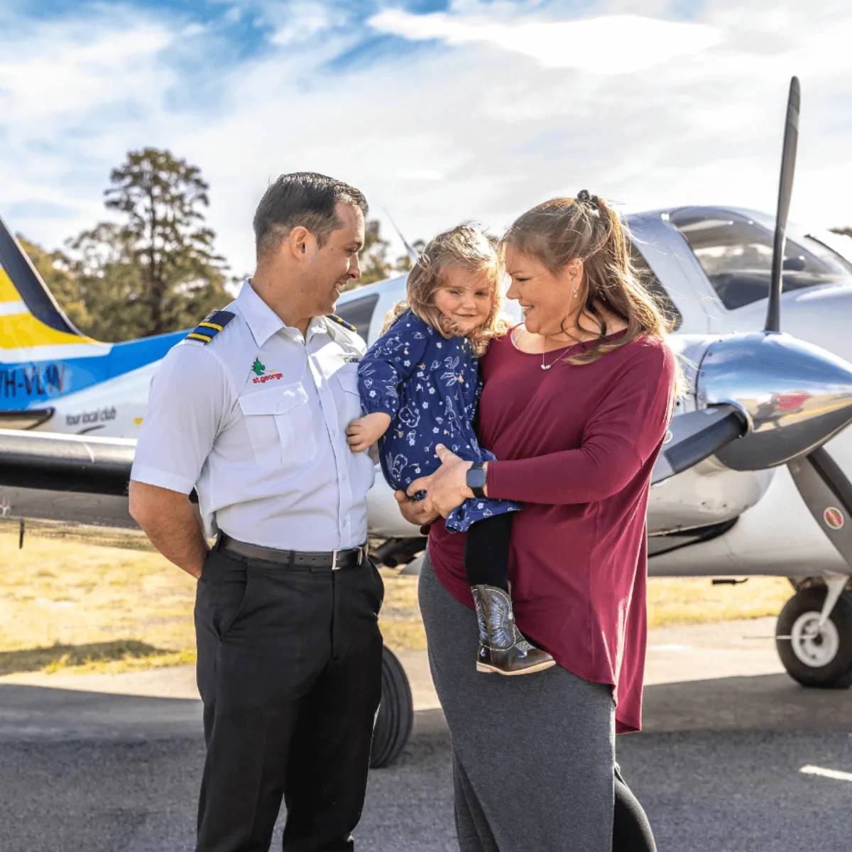 a pilot with small child and parent in front of the Little Wings plane