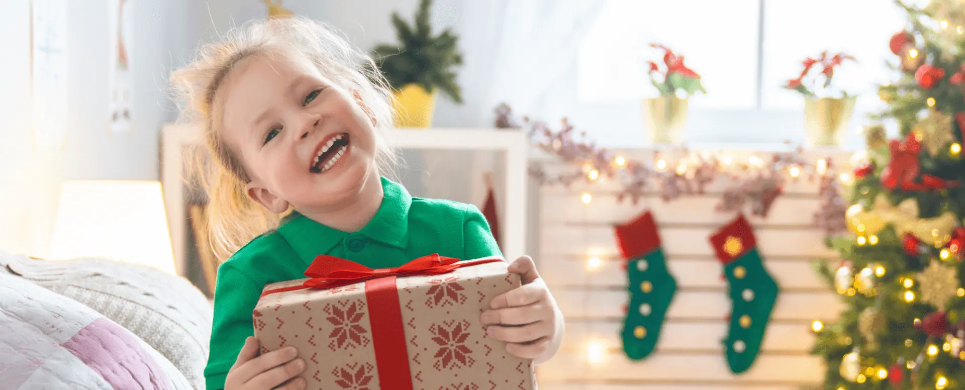 a happy smiling little girl with a gift wrapped box
