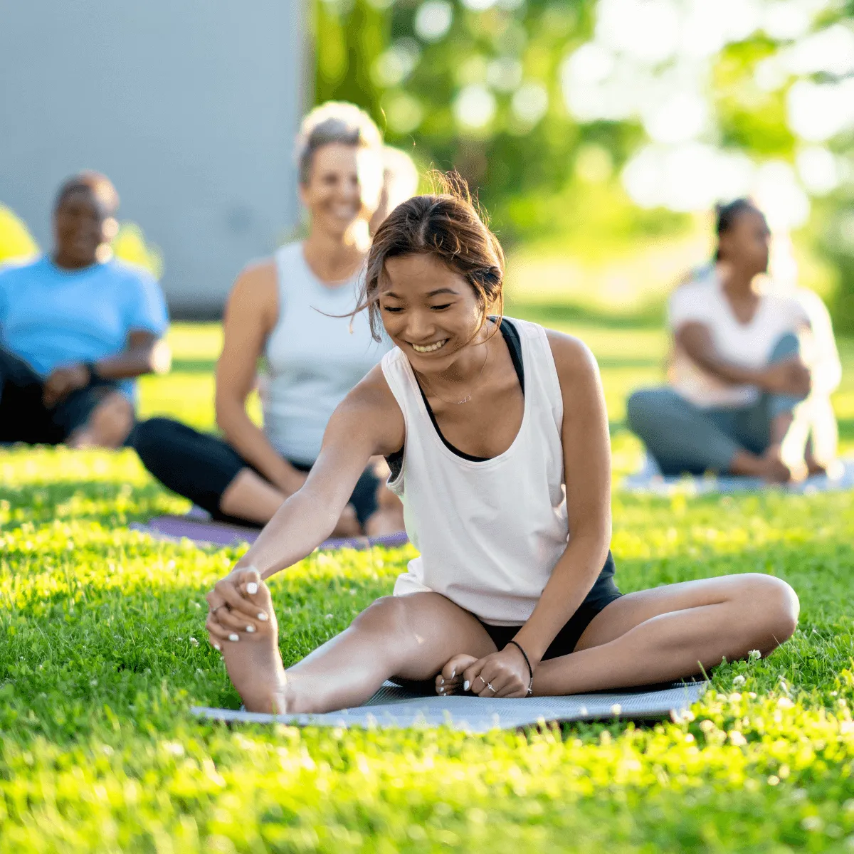 happy looking women practicing yoga outdoors