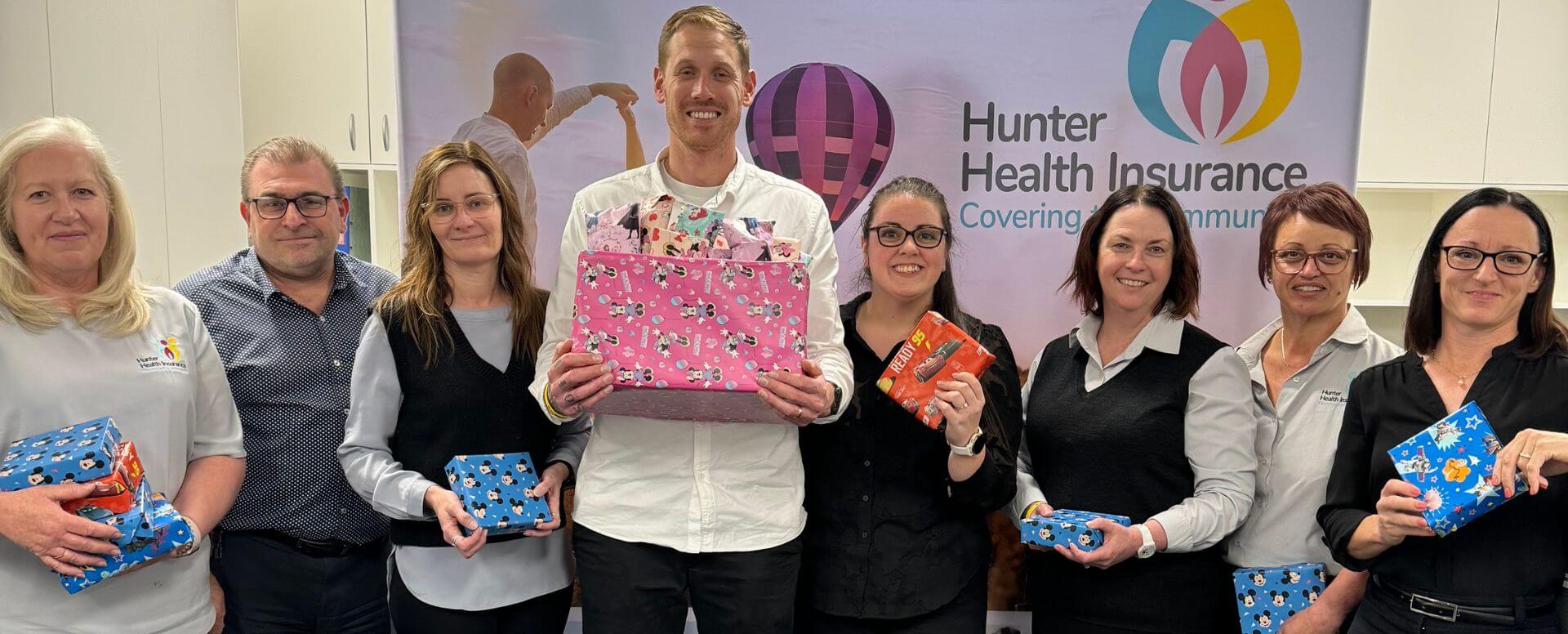 Hunter Health Insurance team holding wrapped christmas presents