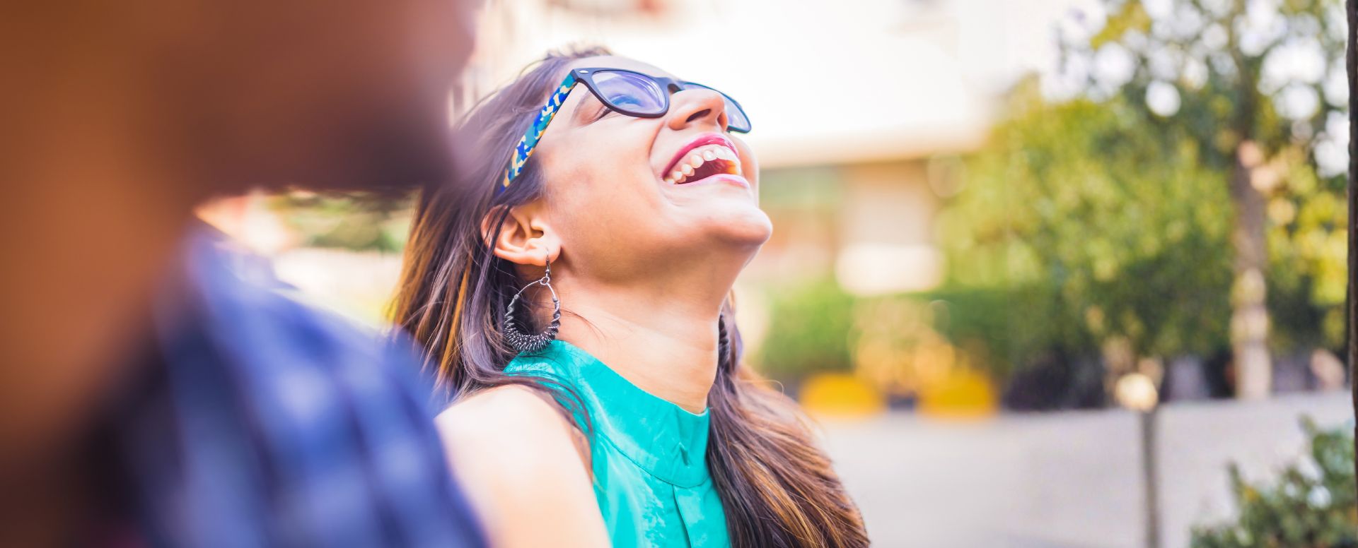woman with glasses laughing outside