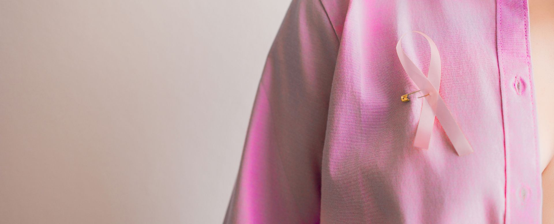 woman with breast cancer ribbon pinned to blouse